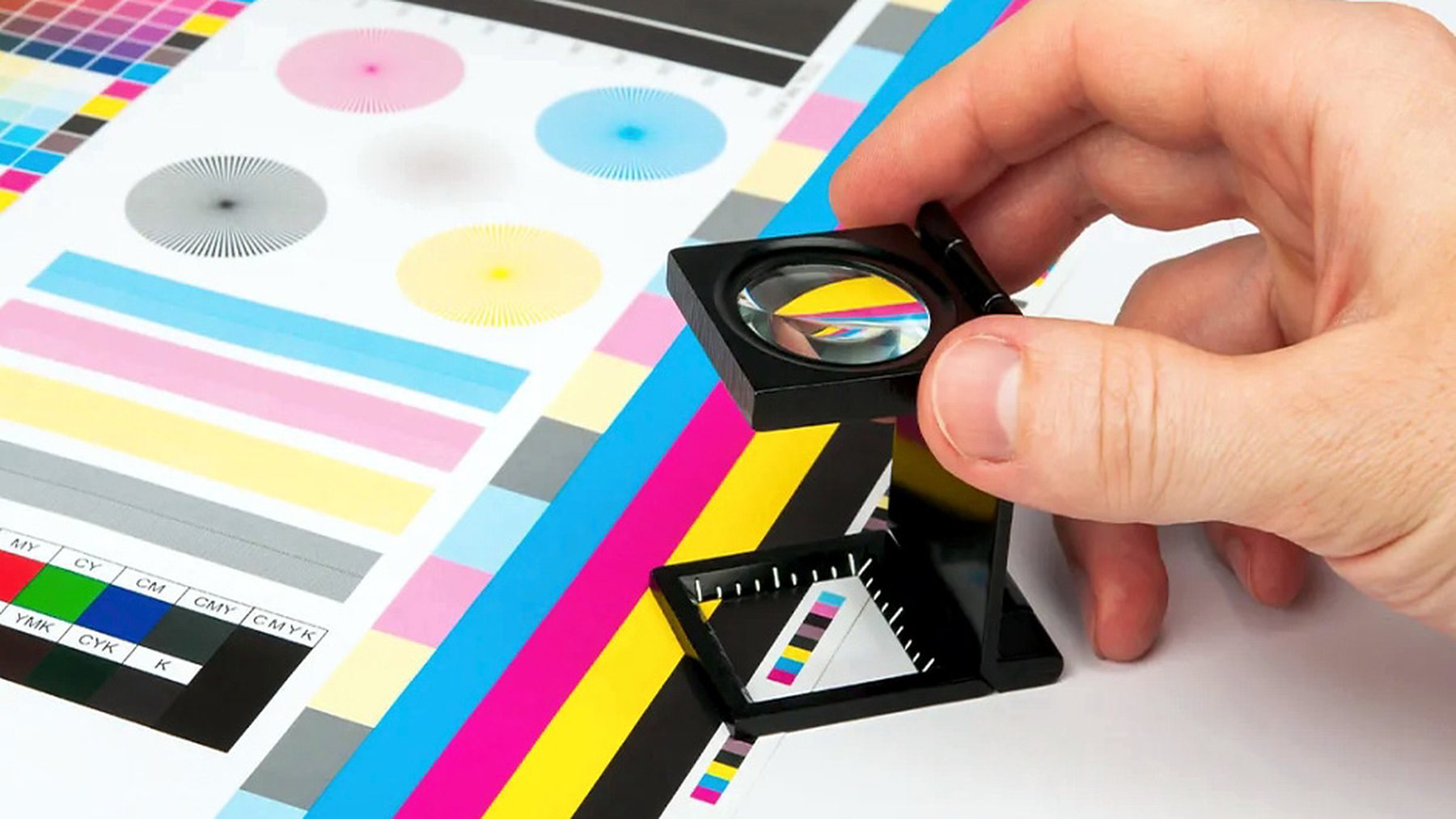 A printed colour control bar being read through a loupe